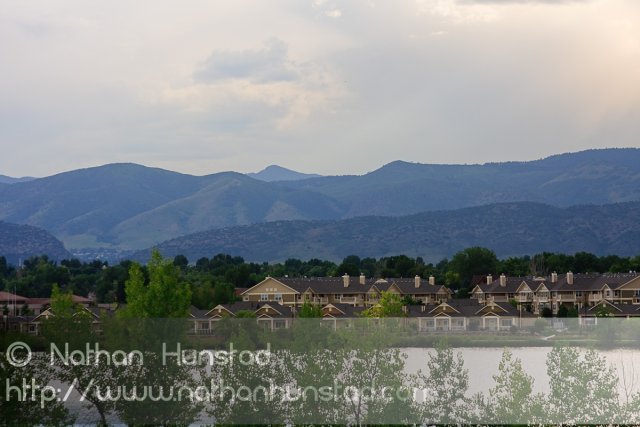 The Hogbacks behind houses on a lake at the Colorado Irish Festival